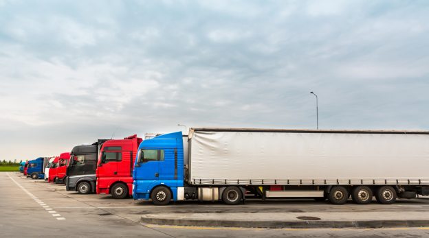 diversos modelos de caminhão em estacionamento representando a altura caminhão