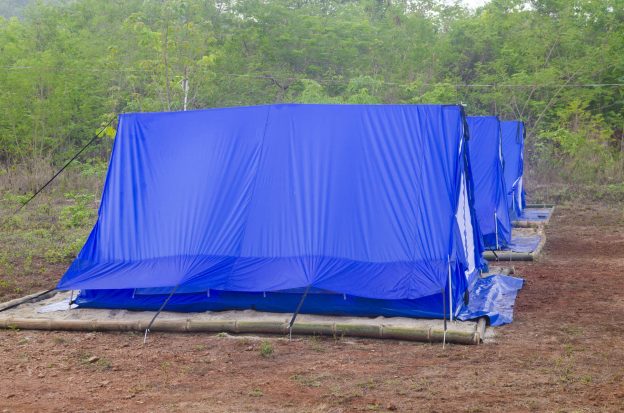 Lona reforçada azul utilizada como cobertura resistente em estrutura externa, protegendo contra chuva, sol e condições climáticas