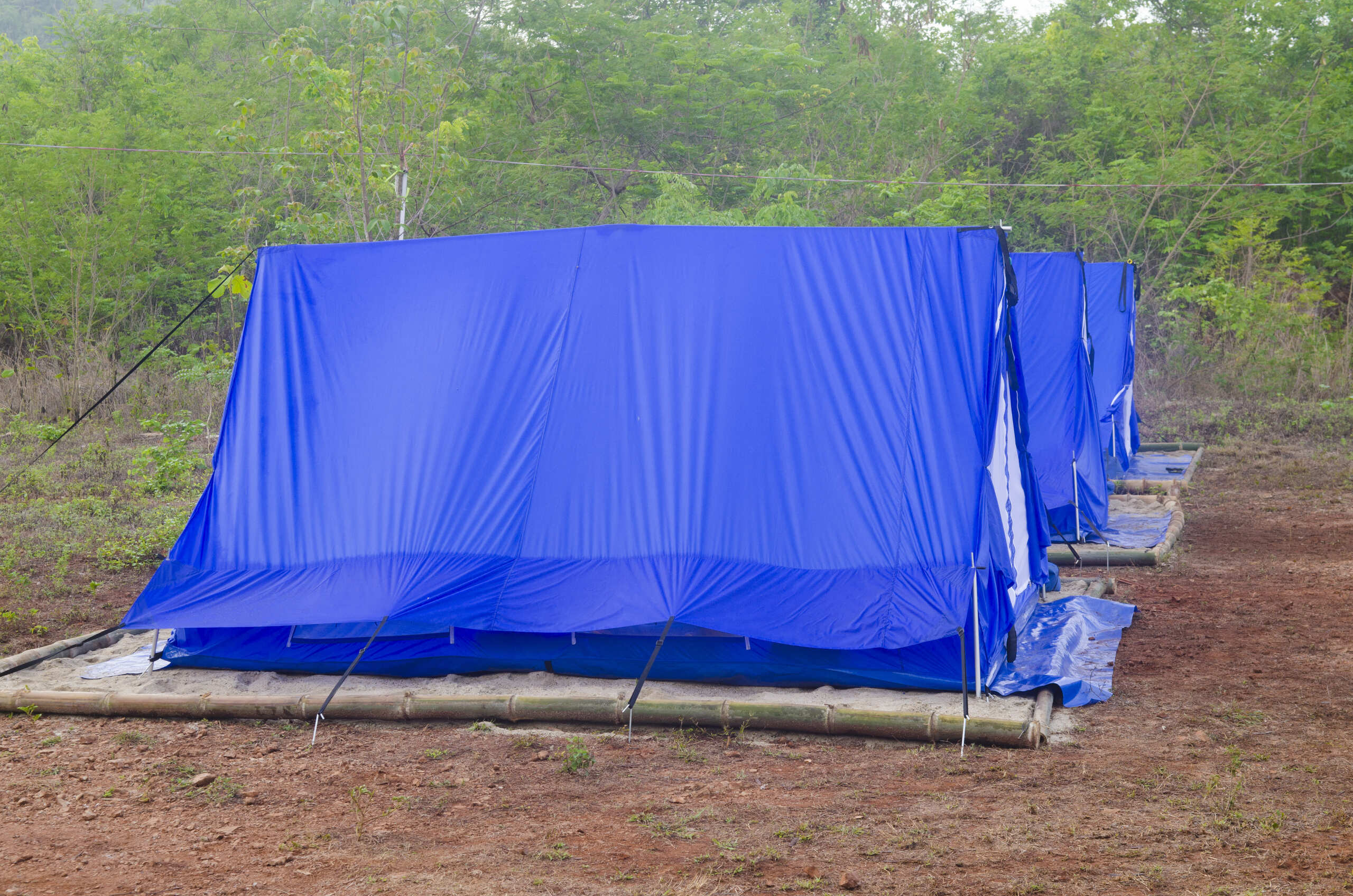 Lona reforçada azul utilizada como cobertura resistente em estrutura externa, protegendo contra chuva, sol e condições climáticas